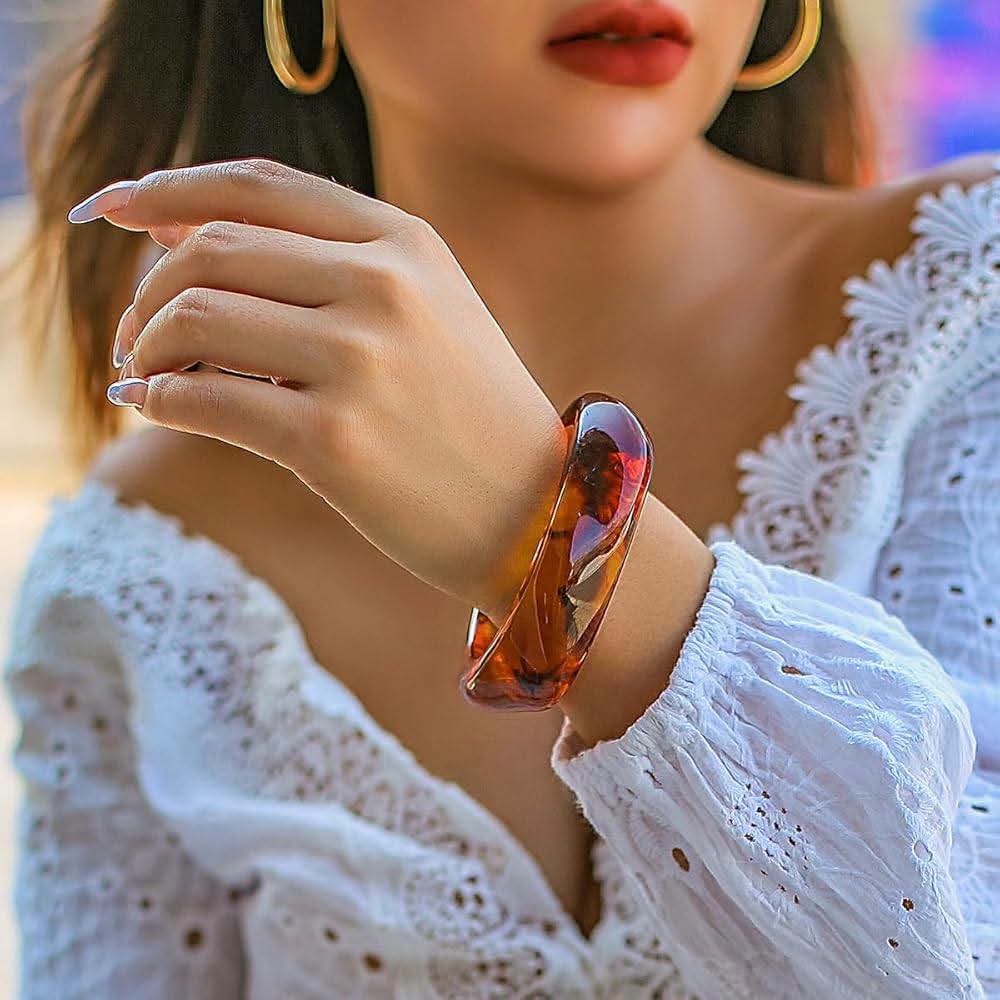 A sculptural bracelet styled on a woman wearing a white blouse